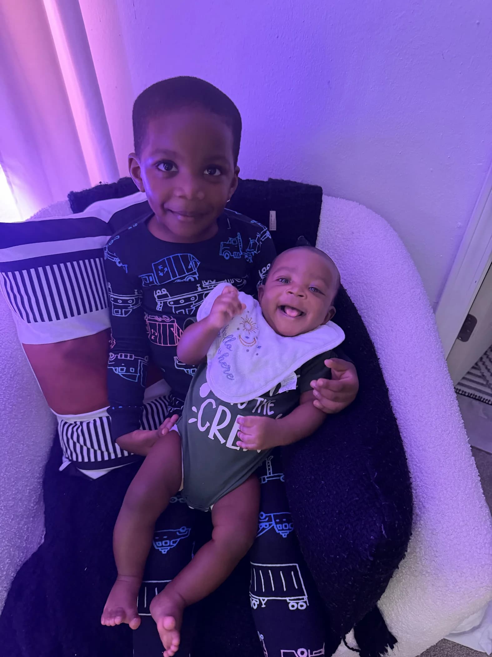 Mykah holding a smiling Malakai in his lap